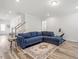 Cozy living room boasts a blue sectional, neutral walls, and modern wood-look flooring at 421 Long Lake Dr, Fuquay Varina, NC 27526
