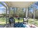 Cozy screened porch is furnished with chairs, offering a relaxing view of the backyard at 421 Long Lake Dr, Fuquay Varina, NC 27526