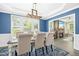 Elegant dining room with a tray ceiling, modern lighting, and a view of the stone fireplace and hearth at 44 S Wilders Ridge Way, Clayton, NC 27527