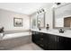 Luxury main bathroom offering dual sink vanity, soaking tub, modern finishes, and decorative mirrors at 44 S Wilders Ridge Way, Clayton, NC 27527