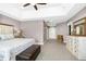 Large main bedroom boasting an ensuite bathroom, carpeted floors, modern furnishings and a ceiling fan at 44 S Wilders Ridge Way, Clayton, NC 27527