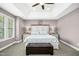 Comfortable main bedroom with tray ceiling, plush carpet, and a beautiful decorative wreath above the headboard at 44 S Wilders Ridge Way, Clayton, NC 27527