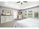 Bright main bedroom with comfortable chair, three windows, plush carpet, and a white dresser at 44 S Wilders Ridge Way, Clayton, NC 27527
