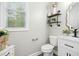 Charming powder room featuring modern fixtures, stylish shelving, and a decorative vanity mirror at 44 S Wilders Ridge Way, Clayton, NC 27527