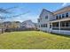Spacious backyard with lush green grass, a privacy fence, and covered porch at 490 Boulder Point Dr, Chapel Hill, NC 27516