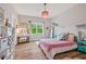 Lovely bedroom features a window, pink bedspread, wood floors, and a pink chandelier at 490 Boulder Point Dr, Chapel Hill, NC 27516