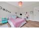 Bedroom features wood floors, neutral paint, a pink chandelier, and a double bed at 490 Boulder Point Dr, Chapel Hill, NC 27516