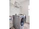 Modern laundry room with stainless steel washer and dryer, shelving, and tile flooring at 490 Boulder Point Dr, Chapel Hill, NC 27516