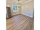 An inviting dining area featuring hardwood floors, modern lighting, and ample natural light at 50 Lakewood Dr, Roxboro, NC 27573
