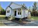 Exterior elevation featuring white siding, natural wood columns, a covered front porch and manicured landscaping at 50 Lakewood Dr, Roxboro, NC 27573