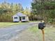 Beautiful shot of the property featuring mature trees and long gravel driveway at 50 Lakewood Dr, Roxboro, NC 27573