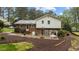 View of the backyard featuring brick accents, mulch landscaping, and an outdoor swing set at 505 Forest Rd, Oxford, NC 27565