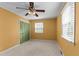 Bedroom with neutral carpet, mustard-colored walls, and a green door at 505 Forest Rd, Oxford, NC 27565