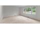 Bright bedroom with neutral carpet, ample natural light from a large window overlooking the front yard at 505 Forest Rd, Oxford, NC 27565