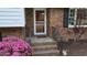 Charming brick home entrance featuring a cozy front porch and beautiful pink flowers in a well-maintained landscape at 505 Forest Road Rd, Oxford, NC 27565