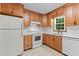A bright kitchen features white appliances, white countertops and a window with wooded cabinets at 505 Forest Road Rd, Oxford, NC 27565