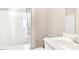 Bathroom featuring a shower-tub combo, white tiled walls, a sink and light beige walls at 507 Presque Isle Ln # Bldg 500, Chapel Hill, NC 27514