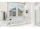 Bright bathroom featuring a soaking tub, tiled walls, and a large window with blinds at 507 Presque Isle Ln # Bldg 500, Chapel Hill, NC 27514