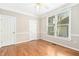 A minimalist bedroom boasts neutral walls, hardwood floors, a ceiling fan, and a view of the backyard at 507 Presque Isle Ln # Bldg 500, Chapel Hill, NC 27514