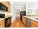 Functional kitchen with wooden cabinets, black appliances, and a view into the adjacent dining area at 507 Presque Isle Ln # Bldg 500, Chapel Hill, NC 27514