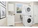 Functional laundry room with a stacked washer and dryer, sink, storage cabinet, and natural light at 507 Presque Isle Ln # Bldg 500, Chapel Hill, NC 27514