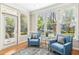 A sunroom with comfortable seating and natural light streaming through large windows overlooking the landscaped yard at 507 Presque Isle Ln # Bldg 500, Chapel Hill, NC 27514