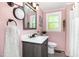 Bathroom featuring a modern vanity, stylish mirror, and shower with charming pink walls at 509 N Elm St, Benson, NC 27504