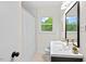 Bright bathroom with white tiling, a modern vanity, a large mirror, and a window providing ample natural light at 513 Hugo St, Durham, NC 27704