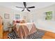Bedroom with wood floors, a ceiling fan, an area rug and two windows offering great natural light at 513 Hugo St, Durham, NC 27704