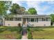 Charming single-story home with a brick facade, a metal roof, and a well-manicured lawn and mature trees at 513 Hugo St, Durham, NC 27704