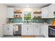Modern kitchen with white cabinets, stainless steel appliances, open shelves, and a light green tiled backsplash at 513 Hugo St, Durham, NC 27704