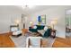 Stylish living room featuring hardwood floors, a comfortable green sofa, and an eye-catching piece of artwork at 513 Hugo St, Durham, NC 27704