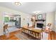 Open living space with hardwood floors connects to kitchen, enhancing a cozy brick fireplace feature at 513 Hugo St, Durham, NC 27704