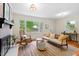 Cozy living room with a brick fireplace, comfortable seating, and natural light streaming through the windows at 513 Hugo St, Durham, NC 27704