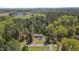 Aerial view of a home nestled within a lush, green landscape, featuring a pond and plenty of trees at 5604 Bobcat Rd, Chapel Hill, NC 27516