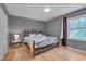 Bedroom with gray walls, wood floors, iron bed frame, and a bright window at 5604 Bobcat Rd, Chapel Hill, NC 27516