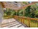 Exterior deck featuring wooden beams, rails, and floor with a view to the backyard and woods at 5604 Bobcat Rd, Chapel Hill, NC 27516