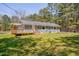 Exterior view of a home featuring a deck, a well-kept lawn, mature trees, and a blue/gray paint at 5604 Bobcat Rd, Chapel Hill, NC 27516