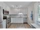 Bright kitchen featuring white cabinets, stainless steel appliances, and a subway tile backsplash at 5604 Bobcat Rd, Chapel Hill, NC 27516