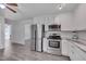 Open-concept kitchen with stainless steel appliances, white cabinets, and easy access to living areas at 5604 Bobcat Rd, Chapel Hill, NC 27516