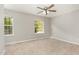 Bedroom featuring neutral walls and carpet, two bright windows, and ceiling fan at 601 E Dynasty Dr, Cary, NC 27513