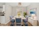 Dining room featuring a large white table with blue chairs, modern decor, and great natural light at 601 E Dynasty Dr, Cary, NC 27513
