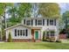 Charming two-story home with vinyl siding, black shutters, a well-manicured lawn, and a brightly colored teal front door at 601 E Dynasty Dr, Cary, NC 27513