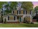 Charming two-story home with vinyl siding, black shutters, a well-manicured lawn, and a brightly colored teal front door at 601 E Dynasty Dr, Cary, NC 27513
