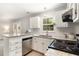 Well-lit kitchen featuring granite countertops, stainless steel appliances, and white cabinets at 601 E Dynasty Dr, Cary, NC 27513