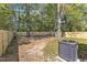 Fenced backyard with mature trees, green grass, and the house's AC unit on a concrete pad at 617 Ray St, Selma, NC 27576