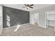 Spacious bedroom featuring a decorative accent wall, ceiling fan, and an adjoining bathroom and walk-in closet at 617 Ray St, Selma, NC 27576