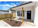 Inviting front porch with natural wood columns, black door, and landscaped garden at 617 Ray St, Selma, NC 27576