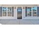Close-up of front door flanked by windows with black shutters and sconces at 619 Ray St, Selma, NC 27576