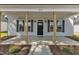 View of front porch with wooden support columns, a black front door, and black shutters at 619 Ray St, Selma, NC 27576
